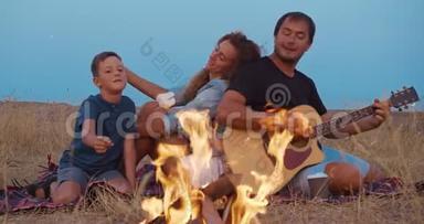 晚上在海滩野餐时，一家人都很快乐。